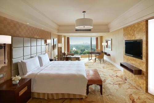 a hotel room with a large bed and a television at Fairmont Yangcheng Lake in Kunshan