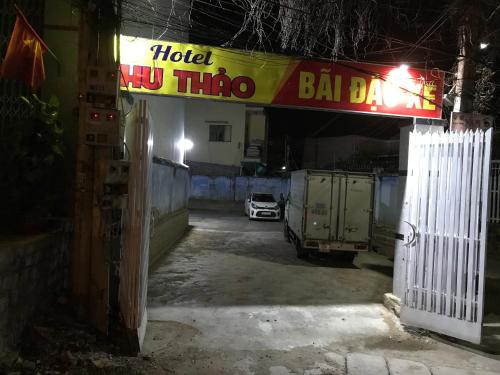 uma garagem com um carro estacionado sob uma placa de bar hollywood em Khách sạn Thu Thảo em Phan Rang