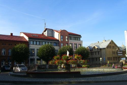 a group of buildings with a fence and flowers at Dom Wczasowy Pięciu Pomostów in Czaplinek