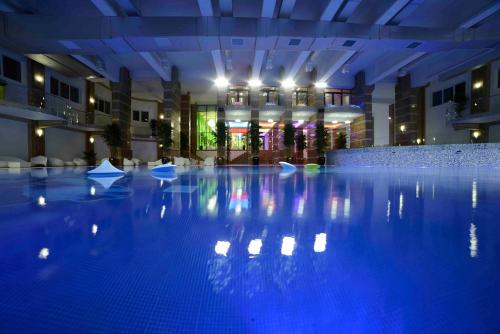 a large swimming pool with blue lights in a building at Militari Residence Studio in Roşu