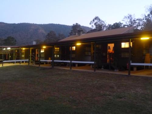 a large building with lights on in a field at Christmas Creek Café & Cabins in Lamington