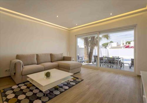 a living room with a couch and a table at Vicky Rae Beach House - Vale do Lobo in Almancil