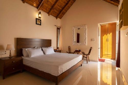 a bedroom with a bed and a table and a mirror at StayVista at Lake Trails with Lawn, Balcony & Lake View in Nainital