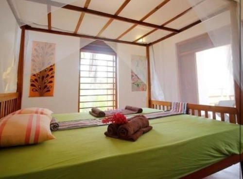 a large green bed in a room with a window at Hidden Garden Tangalle in Tangalle