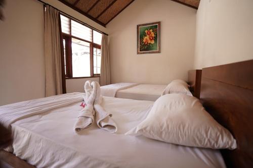een slaapkamer met 2 bedden en handdoeken bij Griya Nusa in Nusa Penida