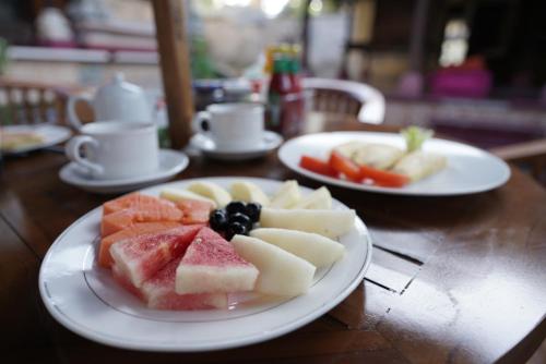 a table with two plates of fruit on it at Griya Nusa in Nusa Penida