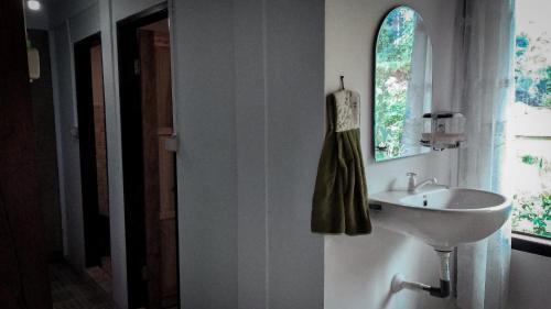 ein Bad mit einem Waschbecken und einem Spiegel in der Unterkunft Mama Tia Family Homestay in Rantepao
