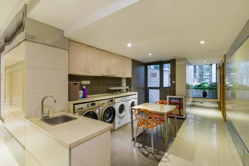 a kitchen with a washer and a sink and a table at Guangzhou Timmy Hotel in Guangzhou