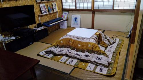 a room with a bed with a laptop on it at HACHI in Odate