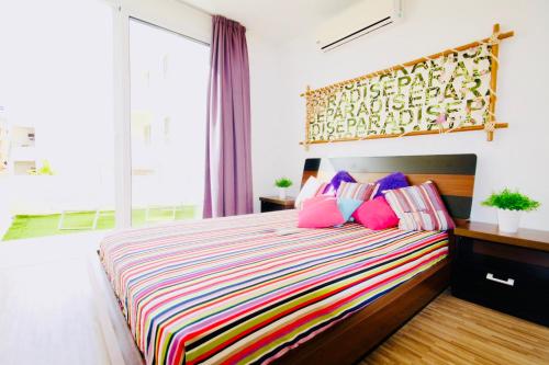 um quarto com uma cama grande e almofadas coloridas em Big 2 Bedroom, XXL Pool, in Hearth of Ayia Napa em Agia Napa