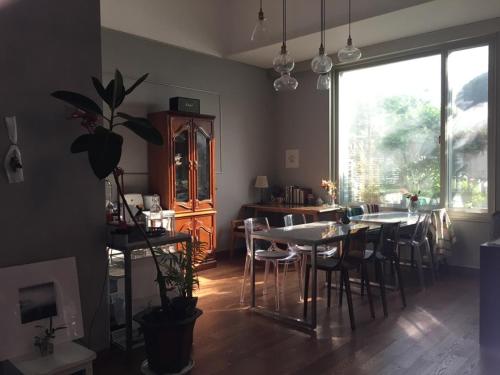 a dining room with tables and chairs and a large window at Charmant Hotel in Mokpo