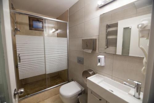 a bathroom with a shower and a toilet and a sink at City Hostel Dormitory in Trâblous