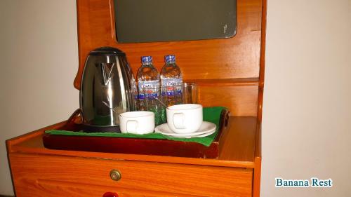 a shelf with a coffee maker and cups on a table at Banana Rest Sigiriya in Sigiriya