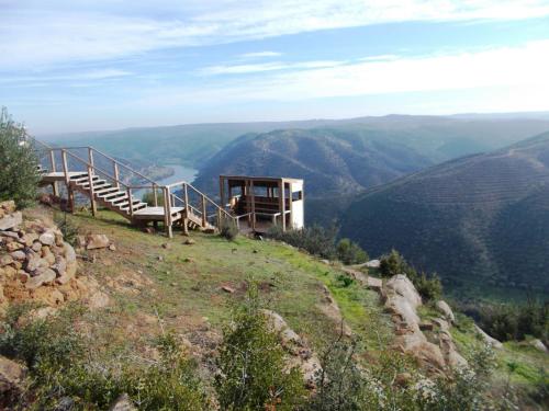 a building on a hill with a view of a valley at Casas de Campo de Vale de Junco in Envendos