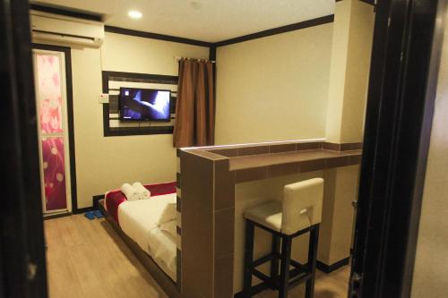 a bedroom with a bed and a mirror and a stool at HOTEL PREMIUM in Ipoh