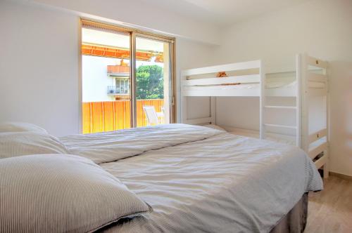 une chambre avec un lit et une grande fenêtre dans l'établissement Modern Family Home 5 min to Beach +Pool +Garage, à Antibes
