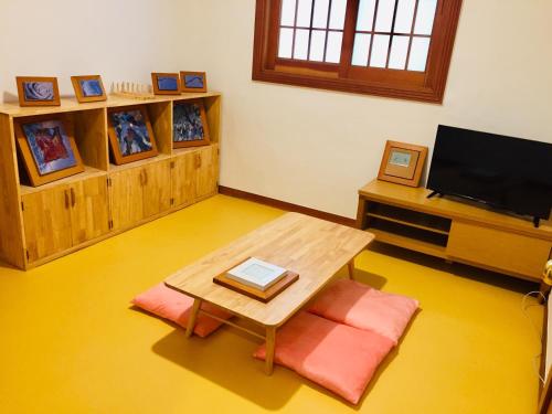 a living room with a table and a tv at BluePlanet in Gyeongju