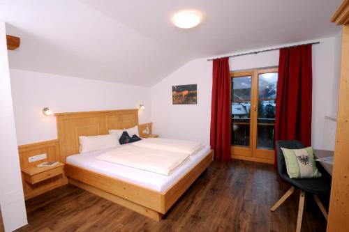 a bedroom with a bed and a desk and a window at Freihaushof in Mayrhofen