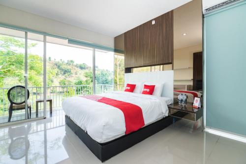 1 dormitorio con 1 cama grande y balcón en OYO 2001 Taman Dayu Villa Golf View, en Pasuruan
