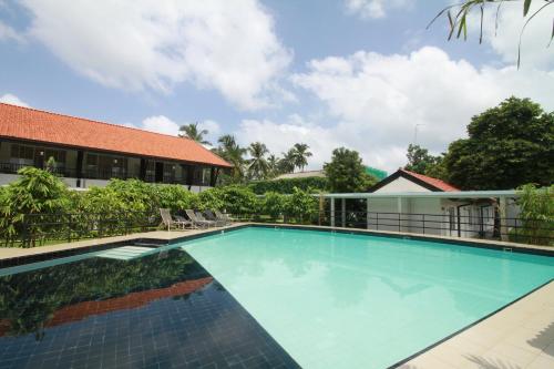 a swimming pool in front of a building at Garden Beach Hotel Kalutara in Kalutara