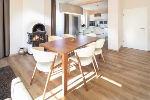 a kitchen and dining room with a wooden table and chairs at Winkelschiffchen II mit Sauna in Juist