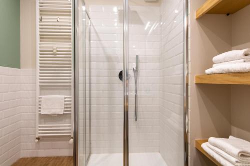 a shower stall in a bathroom with white tiles at aqualago casa vacanze apartment E in Verbania