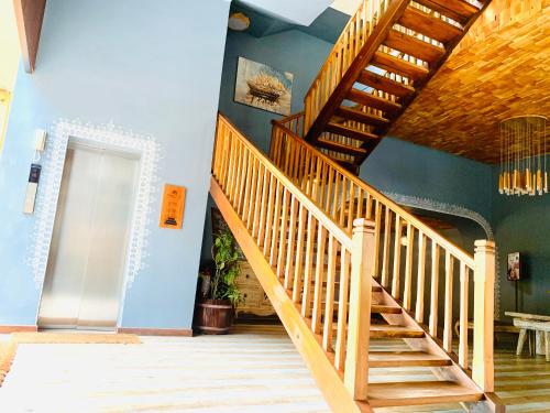 a wooden staircase in a room with a blue wall at Thaproban Pavilion Waves in Unawatuna