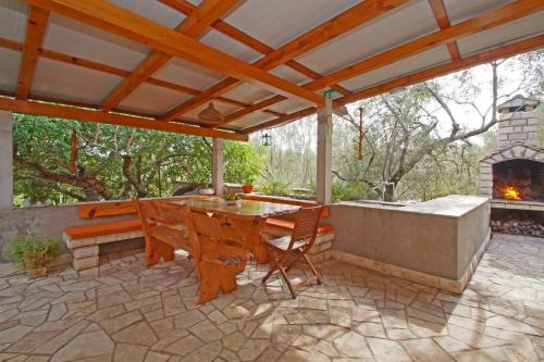 Vacation House Planika في فيلا لوكا: فناء في الهواء الطلق مع طاولة ومدفأة