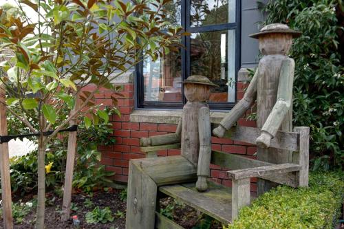 a statue of two people sitting on a bench at Country Glen Lodge in Christchurch