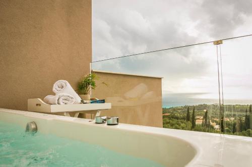 a bathroom with a tub with a view of the ocean at Diana Suites in Trapezaki