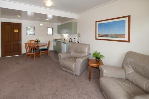 a living room with a couch and a table at Country Glen Lodge in Christchurch