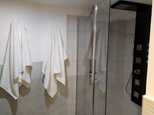 ein Bad mit einer Dusche und weißen Handtüchern in der Unterkunft NAPOLIXSUITE in Neapel