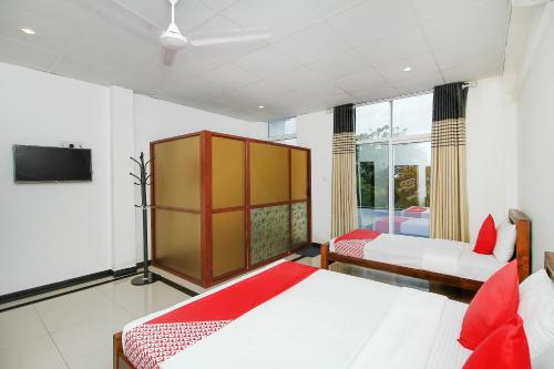 a bedroom with two beds and a tv in it at Grand Rovinka Hotel in Dehiwala