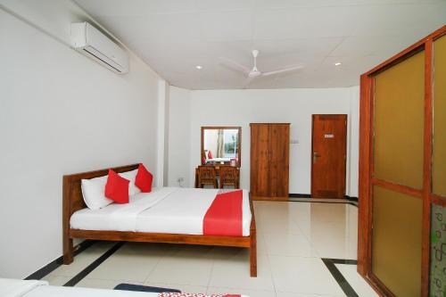 a bedroom with a bed with white and red pillows at Grand Rovinka Hotel in Dehiwala