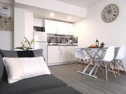 uma cozinha e sala de estar com mesa e cadeiras em Beachfront modern and spacious apartment em Torrevieja