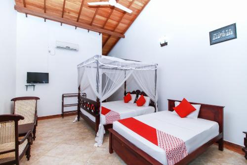 a bedroom with two beds and a tv at Chami Villa Bentota in Bentota