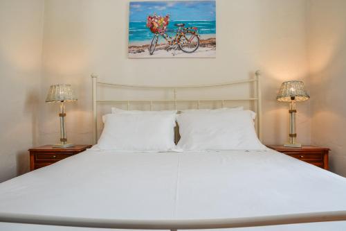 a bedroom with a white bed with a bicycle on the wall at The Veranda of Gavrion-Exclusive, Centrally located with Seaview in Gavrion