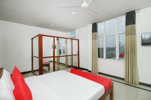 a bedroom with a bed and a window at Grand Rovinka Hotel in Dehiwala
