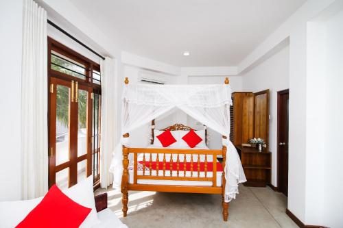 a bedroom with a bed with a canopy at Arken Lanka in Galle