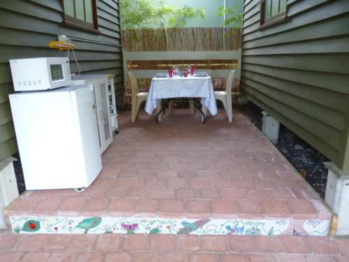 a table and chairs sitting on a brick patio at Christmas Creek Café & Cabins in Lamington