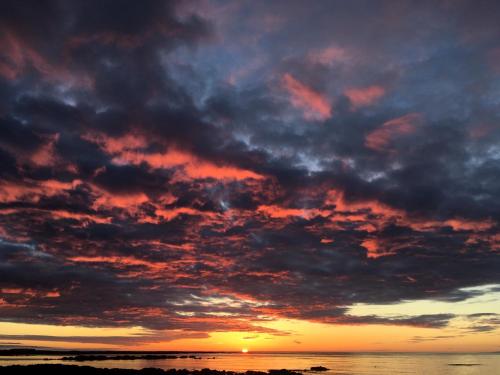 a cloudy sky at sunset over the ocean at The Bookstore Family Apartment in Hellissandur
