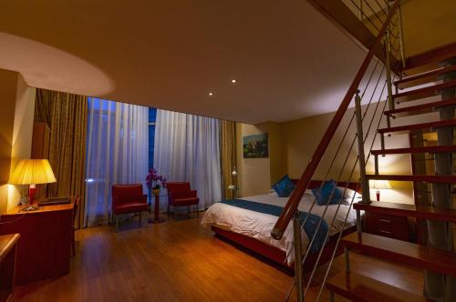 a bedroom with a bed and a spiral staircase at East King Business Hotel (West Lake store, Hangzhou) in Hangzhou