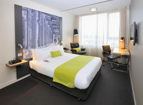 Habitación de hotel con cama y escritorio en Mercure Melbourne Therry Street en Melbourne