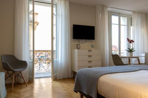 1 dormitorio con 1 cama y vestidor con TV en Aqualago casa vacanze - apartament B, en Verbania