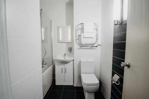 a white bathroom with a toilet and a sink at Banff Springs Hotel in Banff