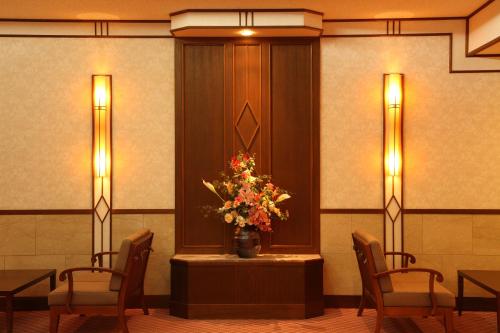 a room with a table with a vase of flowers at Hotel Oak Forest in Hakuba
