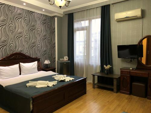 a bedroom with a bed with a mirror and a television at Bonus Hotel in Tbilisi City