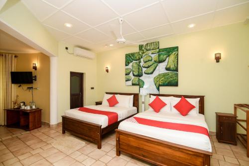 a hotel room with two beds and a tv at Man Mountain Villa in Matale