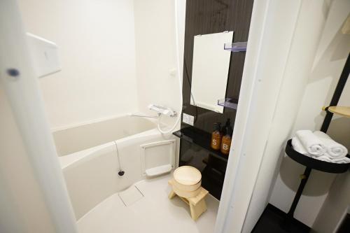 a bathroom with a tub and a toilet and a sink at EARTHMANS OSAKA-JO in Osaka