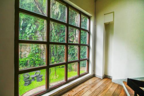 an empty room with a large window with trees at Grand Rockland Hotel in Matara